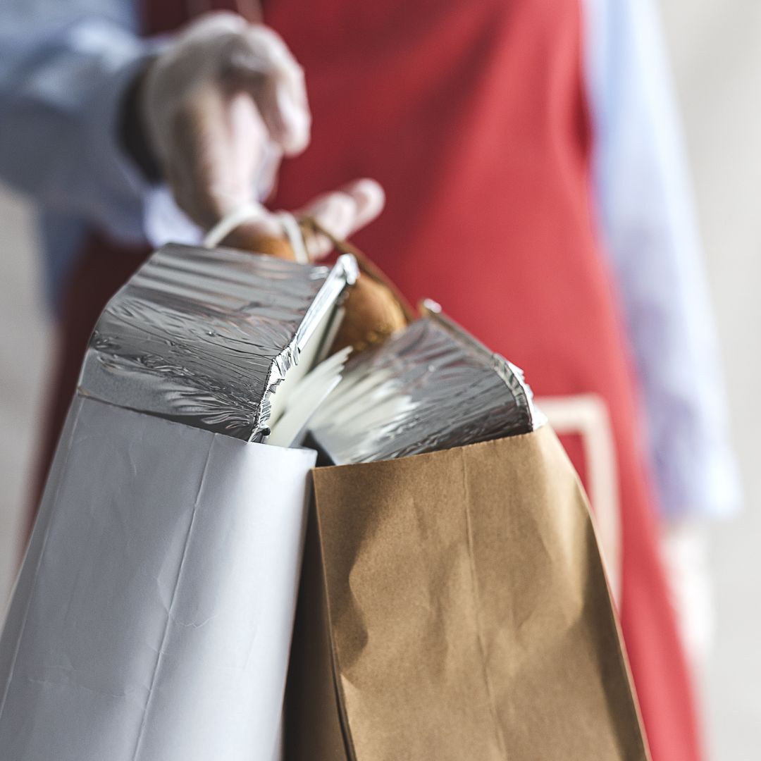 handing over a bag of catering food
